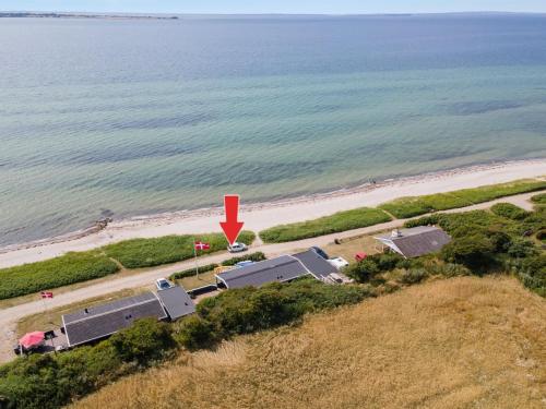 an aerial view of a beach with a red arrow at Holiday Home Pellervo - 20m from the sea in Funen by Interhome in Assens
