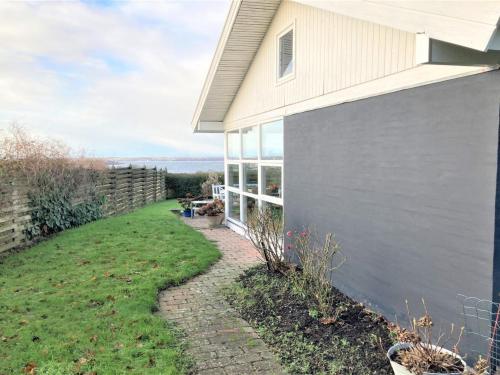 a side view of a house with a yard at Holiday Home Susia - 200m from the sea in Funen by Interhome in Middelfart