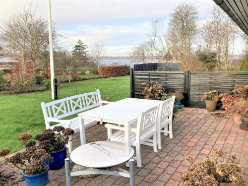 a white table and two chairs on a patio at Holiday Home Susia - 200m from the sea in Funen by Interhome in Middelfart