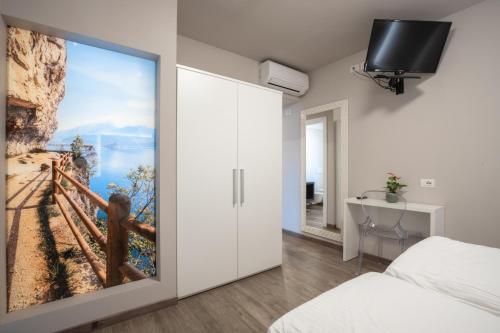 a bedroom with a sliding door with a painting on the wall at Hotel Rolly in Riva del Garda