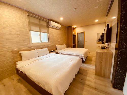 a hotel room with two beds and a window at Beauty Garden Hotel - Jiaoxi in Jiaoxi