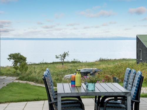 een picknicktafel met 2 stoelen en uitzicht op het water bij Holiday Home Lyly - 100m from the sea in Funen by Interhome in Asperup