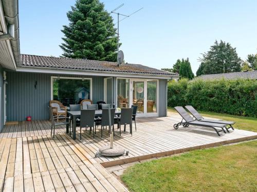 una terraza de madera con mesa y sillas. en Holiday Home Alrich - 500m from the sea in Funen by Interhome, en Svendborg