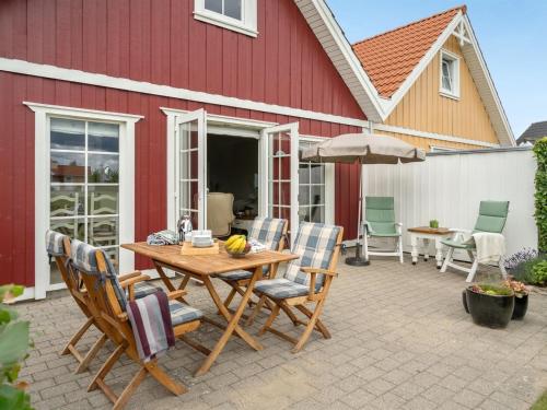 eine Terrasse mit einem Holztisch und Stühlen in der Unterkunft Holiday Home Eike - 250m from the sea in Funen by Interhome in Bro