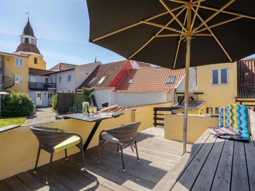 a patio with a table and chairs and an umbrella at Holiday Home Laust - 250m from the sea in Funen by Interhome in Faaborg