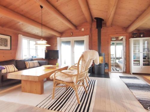 uma sala de estar em madeira com uma mesa de madeira e uma cadeira em Holiday Home Bibi - 200m from the sea in Funen by Interhome em Ebberup