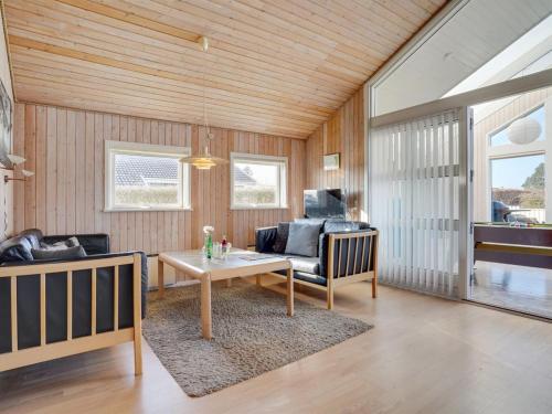 uma sala de estar com uma mesa e um sofá em Holiday Home Dunya - 400m from the sea in Funen by Interhome em Assens