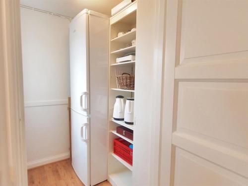 a closet with a white refrigerator and shelves at Holiday Home Store - 700m from the sea by Interhome in Ebberup