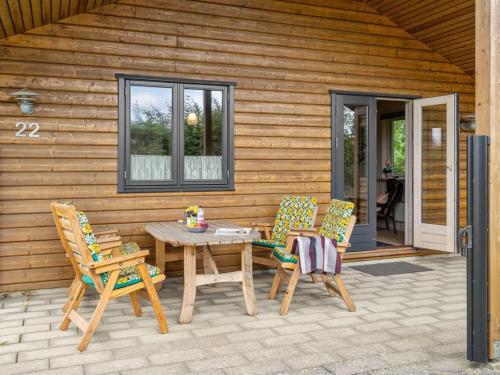 un patio de madera con mesa y 2 sillas en Holiday Home Rəzvan - 120m from the sea in Funen by Interhome, en Vedelshave