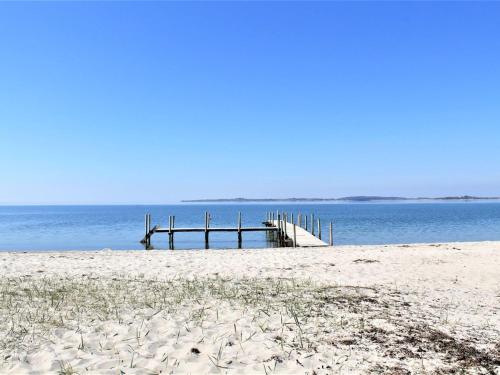eine Anlegestelle am Strand mit Sand und Wasser in der Unterkunft Holiday Home Rise - 250m from the sea in Funen by Interhome in Bøjden