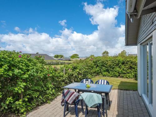 einen blauen Tisch und Stühle auf einer Terrasse in der Unterkunft Holiday Home Rise - 250m from the sea in Funen by Interhome in Bøjden