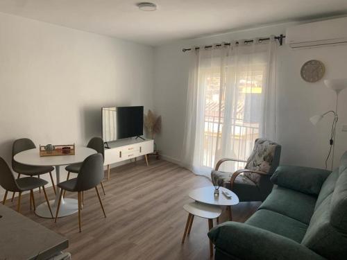 a living room with a couch and a table at Apartamento Peñas Blancas, junto a ruta de los Cahorros, Monachil. in Monachil