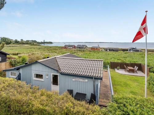 een blauw gebouw met een vlag naast een terras bij Holiday Home Herulf - 100m from the sea by Interhome in Bogentved