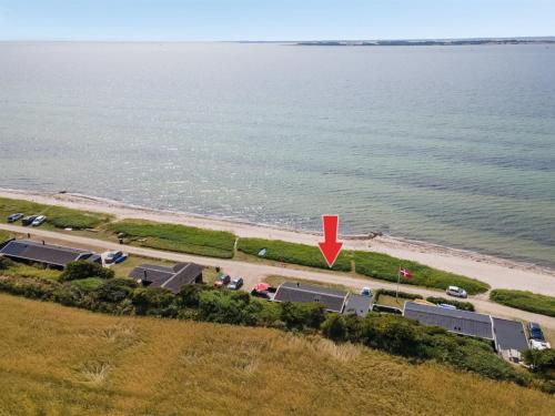 eine Luftansicht auf einen Strand mit einem roten Pfeil in der Unterkunft Holiday Home Akseline - 20m from the sea in Funen by Interhome in Assens