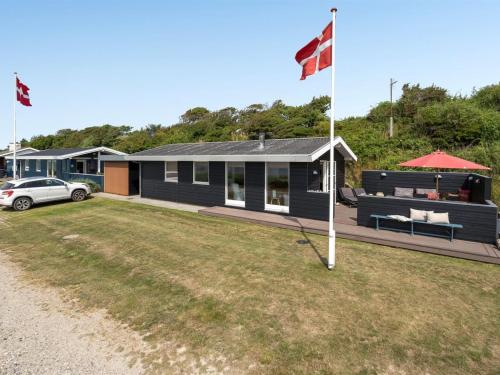 ein Haus mit einer Flagge und einem Auto davor in der Unterkunft Holiday Home Akseline - 20m from the sea in Funen by Interhome in Assens