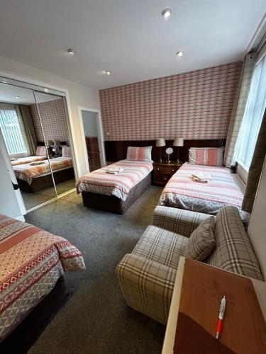 een hotelkamer met 2 bedden en een bank bij Acer Lodge Guest House in Edinburgh