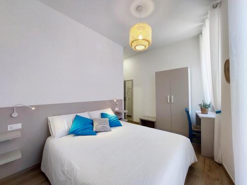 um quarto com uma grande cama branca com almofadas azuis em Affittacamere Casa Lilibet em San Benedetto del Tronto