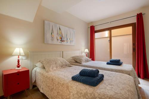 Duas camas num quarto com duas toalhas azuis em Villa Carmen em Caleta de Fuste
