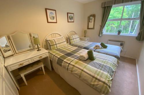 a bedroom with two beds with a teddy bear on the bed at Falcon Lodge in Aviemore
