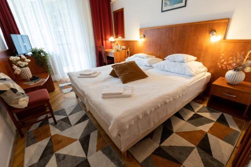 una camera con un grande letto con testiera in legno di HELIOS Hotel Apartments a Budapest
