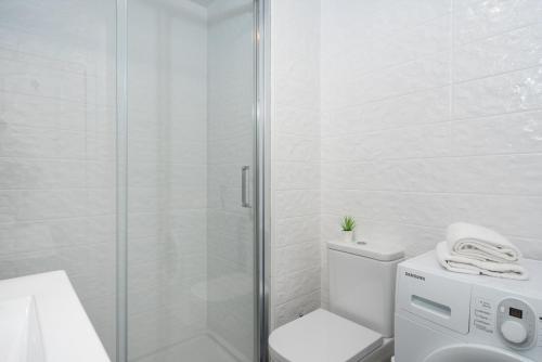 y baño blanco con aseo y ducha. en Lovely flat in Casinomar - Torrequebrada Ref 114, en Benalmádena