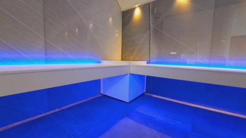 een badkamer met blauwe verlichting in een kamer bij Maisons de Vacances Azur en Ardenne in Durbuy