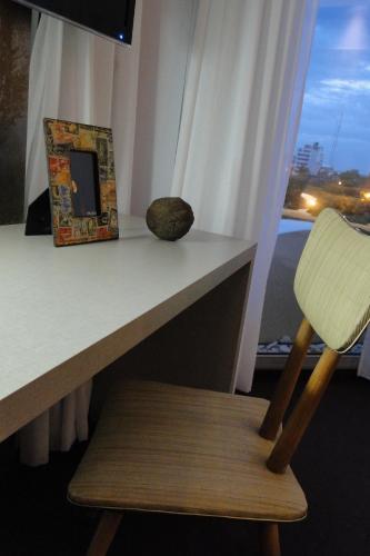 a chair sitting next to a desk with a window at Ambit Boulevard Hotel Boutique in Santa Fe