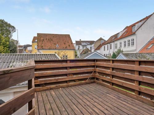 una terraza de madera en un techo con edificios en el fondo en Holiday Home Marilena - 300m from the sea in Funen by Interhome en Rudkøbing