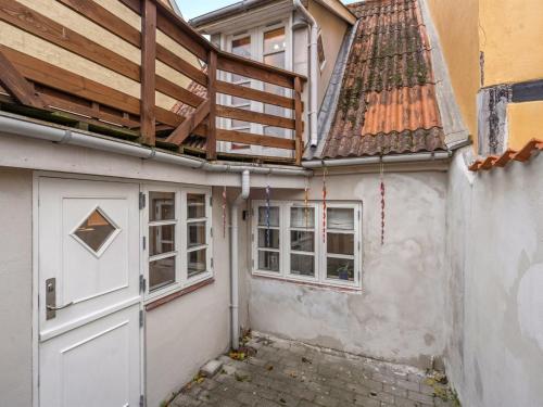 a house with a wooden roof and a door at Holiday Home Marilena - 300m from the sea by Interhome in Rudkøbing