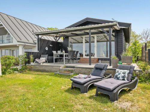 een achtertuin met 2 stoelen en een prieel bij Holiday Home Käthe - 5m from the sea in Funen by Interhome in Middelfart