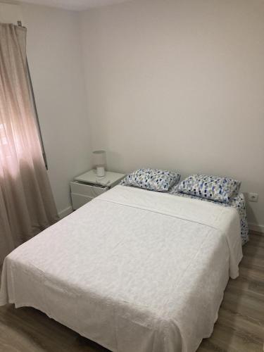 1 dormitorio con cama blanca y almohadas azules en Casa da Marina en Esposende