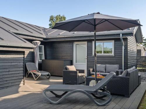 a patio with a table and an umbrella and chairs at Holiday Home Kamilla - 200m from the sea by Interhome in Nyborg