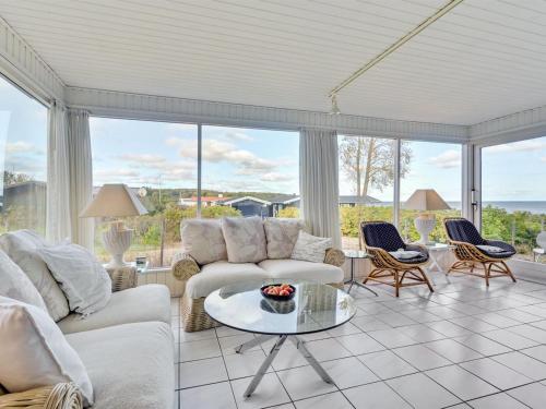 a living room with couches and a table at Holiday Home Rene - 50m from the sea in Funen by Interhome in Hesselager