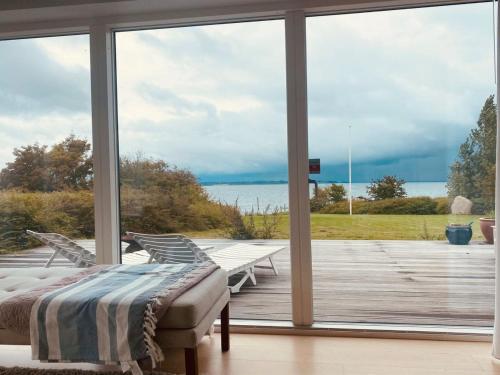 a bedroom with a view of the ocean through a window at Holiday Home Sissela - 5m from the sea by Interhome in Ebberup