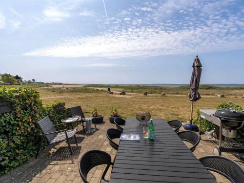 a picnic table with an umbrella and a grill at Apartment Lucjan - 50m from the sea in Funen by Interhome in Assens