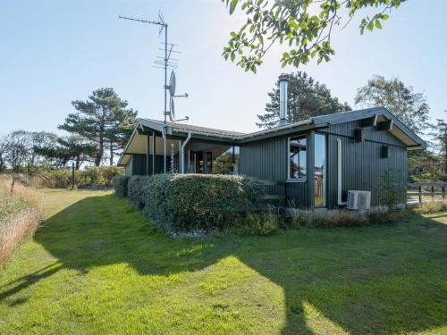 una pequeña casa verde en un campo de hierba en Holiday Home Nnykka - 100m from the sea in Funen by Interhome, en Bøjden