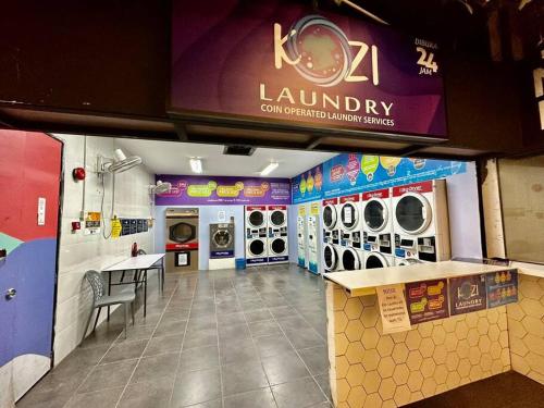 a laundry room with washers and dryers in a store at Kuching Kozi Square Apartment in Kuching
