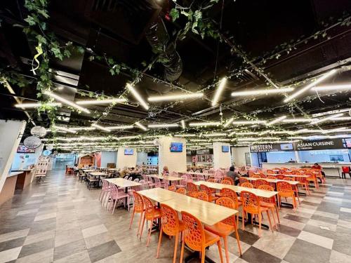 a dining hall with tables and chairs and lights at Kuching Kozi Square Apartment in Kuching