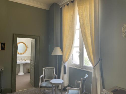 um quarto com uma janela, uma mesa e cadeiras em Hôtel Château des Jacobins em Agen