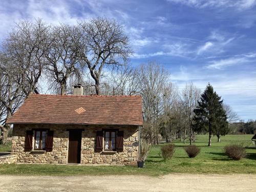 an old stone house in a field with trees at La maisonnette des champs in Pierre-Buffière