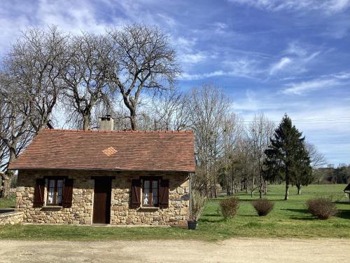 une ancienne maison en pierre dans un champ arboré dans l'établissement La maisonnette des champs, à Pierre-Buffière