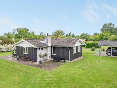una casa en blanco y negro con un patio en Holiday Home Jaike - 350m from the sea in Funen by Interhome, en Tranekær