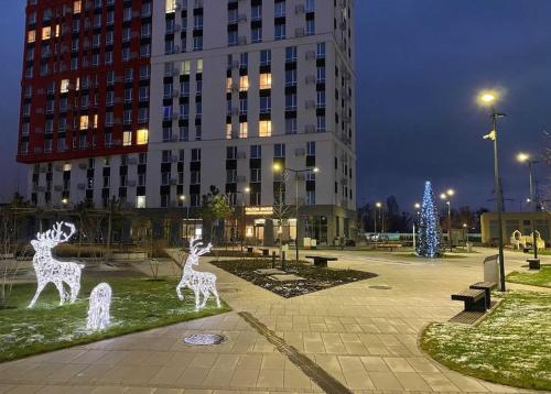 twee standbeelden van herten in een park met een kerstboom bij Квартира в новому ЖК Svitlo Park Київ in Kiev