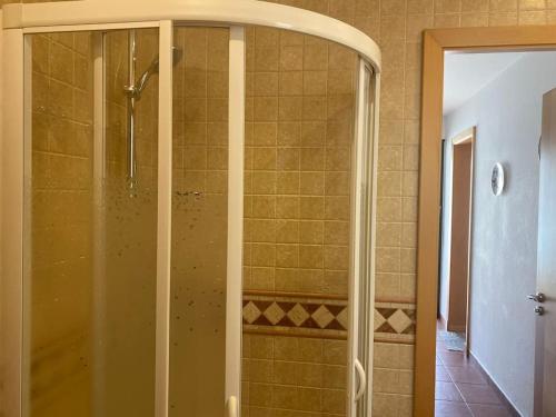 um chuveiro com uma porta de vidro na casa de banho em Apartamento en Na Macaret A em Na Macaret