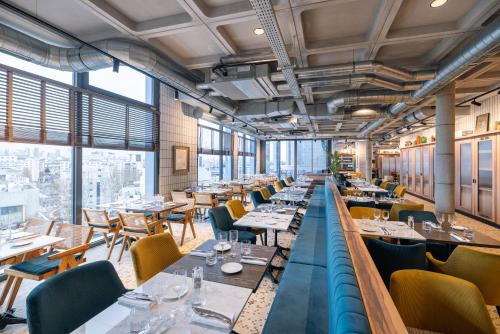 a restaurant with tables and chairs and windows at KOPSTER Hotel Residence Paris Ouest Colombes in Colombes