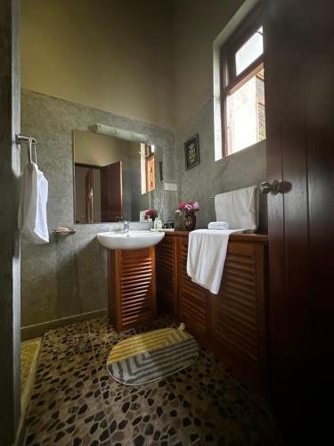 a bathroom with a sink and a mirror at Lanka Golf Villa Collection - Villa Rachel's Sun in Kandy