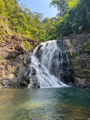 a waterfall in the middle of a body of water at Jar rai village homestay& Sona trekking tour in Banlung