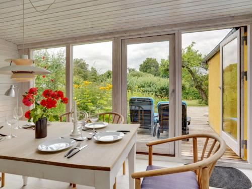 a dining room with a table and chairs and a patio at Holiday Home Gytta - 1km from the sea in Funen by Interhome in Tranekær