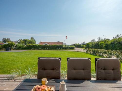 einen Tisch mit 2 Stühlen und eine Schale Obst in der Unterkunft Holiday Home Sebbi - 90m from the sea in SE Jutland by Interhome in Binderup Strand