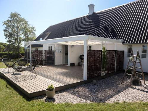a wooden deck with awning on a house at Holiday Home Harre - 300m from the sea in Funen by Interhome in Rudkøbing